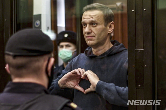 [모스크바=AP/뉴시스]러시아 야권 운동가 알렉세이 나발니가 2일(현지시간) 모스크바 법원에서 열린 집행유예 판결 취소 공판 중 하트를 보내고 있다. 모스크바 법원이 나발니에 대한 집행유예 판결 취소 공판에서 3년 6개월의 실형을 선고했다. 이에 따라 나발니는 가택 연금됐던 1년을 제외한 2년 6개월을 교도소에서 복역하게 됐다. 2021.02.03.