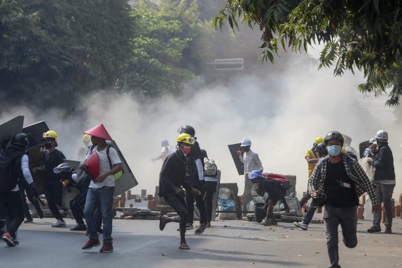 3일 미얀마 만달레이에서 군부 쿠데타 반대 시위대가 경찰이 쏜 최루탄을 피해 달리고 있다. 뉴시스