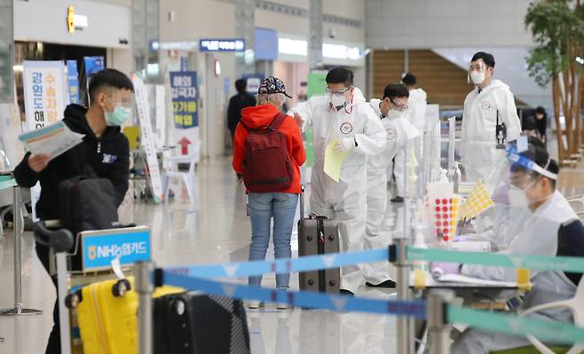 4일 오전 인천국제공항 제2여객터미널에서 해외입국자들가 방역 관계자의 안내를 받고 있다. [연합]