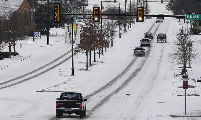 미국 텍사스주에 이례적인 한파가 덮친 지난달 17일 텍사스 북부 도시 포트워스 도로에는 눈이 쌓여있다. 포트워스=EPA연합뉴스