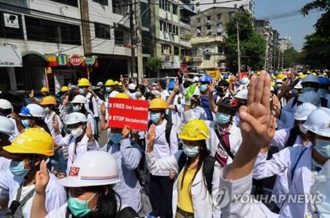미얀마 최대 도시 양곤에서 5일(현지시간) 의료인과 학생들이 군부 쿠데타에 항의하는 시위를 벌이며 저항의 표시로 세 손가락을 세우고 있다. 연합뉴스
