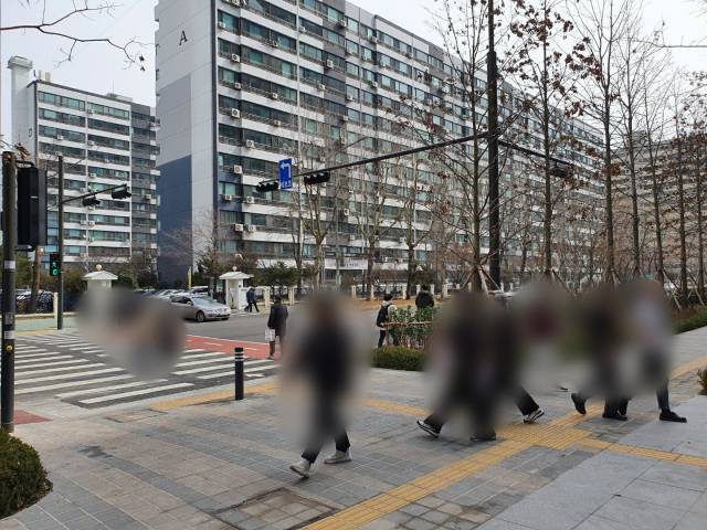 시민들이 5일 서울 영등포구 여의도 더현대서울 앞 인도를 지나고 있다. A 아파트 단지가 횡단보도를 사이에 두고 더현대서울 맞은편에 위치해 있다. /김동현 기자