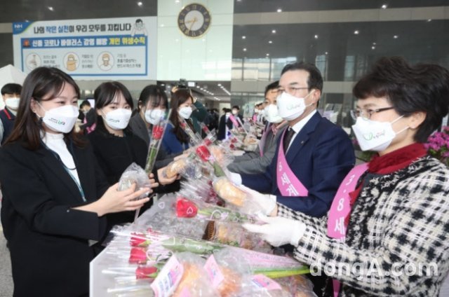 이성희 농협중앙회장(오른쪽에서 두번째)이 8일 세계 여성의 날을 맞아 서울 중구 농협중앙회 본관에서 출근하는 직원들에게 장미꽃과 우리 쌀빵을 나줘주고 있다. 농협 제공
