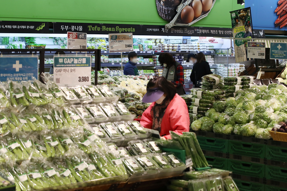 A woman looks at the options in the vegetable section of a discount market in downtown Seoul on Monday. According to Statistics Korea, Korea's food consumer price index in January was up 6.5 percent from same month a year earlier, posting the fourth highest figure in the OECD. [YONHAP]