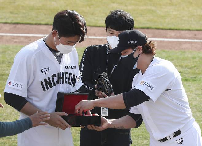 (부산=연합뉴스) 강덕철 기자 = SSG 추신수가 11일 오후 부산 사직구장에서 프로야구 롯데와 연습경기를 끝낸 SSG 선수단과 첫인사를 하면서 자신에게 등번호 ‘17번’을 양보한 이태양에게 시계를 선물하고 있다. 2021.3.11