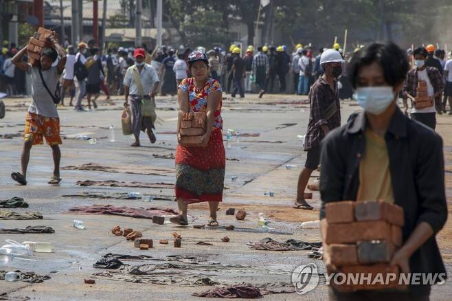 미얀마 반군부 시위대에 벽돌 전달하는 시민들 [양곤 AP=연합뉴스 자료 사진]