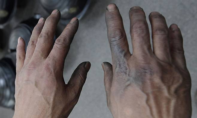 고된 작업으로 까맣게 그을려 있는 김성태 전수자의 손.