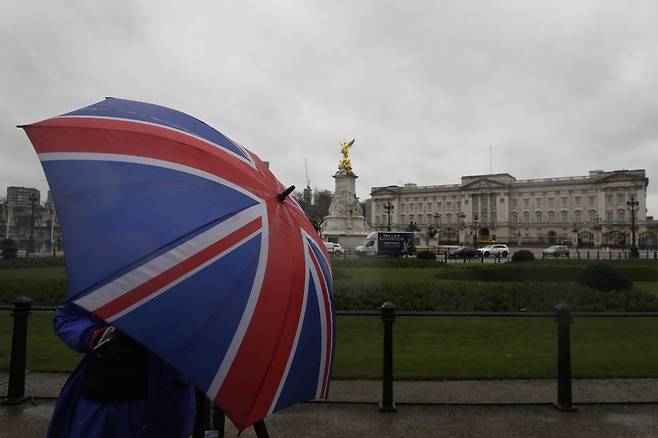 영국 수도 런던에 있는 버킹엄궁 앞을 한 시민이 지나가고 있다. [AP]