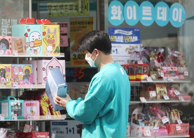 화이트데이인 지난 14일 서울 시내 편의점에서 한 시민이 선물 세트를 고르고 있다. 연합뉴스