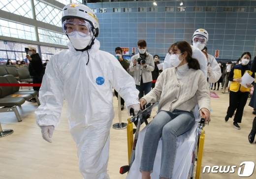 (천안=뉴스1) 김기태 기자 = 17일 오전 충남 천안시 서북구 실내테니스장에 마련된 예방접종센터에서 실시된 지역 예방접종센터 모의훈련에서 의료진이 이상반응 발생 접종대상자를 응급처치실로 이송하고 있다. 2021.3.17/뉴스1