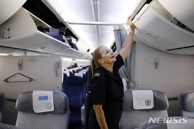 [ 텔아비브( 이스라엘)= AP/뉴시스]이스라엘 항공사 엘알(El Al)의 여승무원 헤드바 오파토프스키가 텔아비브의 벤구리온 국제공항에 착륙한 뒤  기내 짐칸들을 닫고 있다. 이스라엘정부는코로나19로 타격을 입은 국내항공사들에 현금지원을 하는 방안을 17일(현지시간)발표했다.