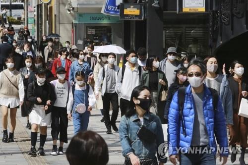 (도쿄 AP=연합뉴스) 일본 수도권에 신종 코로나바이러스 감염증(코로나19) 긴급사태가 발효 중인 가운데 17일 도쿄 시민들이 마스크를 착용한 채 거리를 걸어가고 있다. leekm@yna.co.kr
