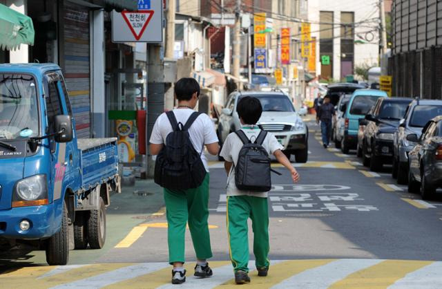 '스쿨존'에서 학생들이 인도와 차도가 구분되지 않은 위험한 도로로 하교하고 있다. 한국일보 자료사진