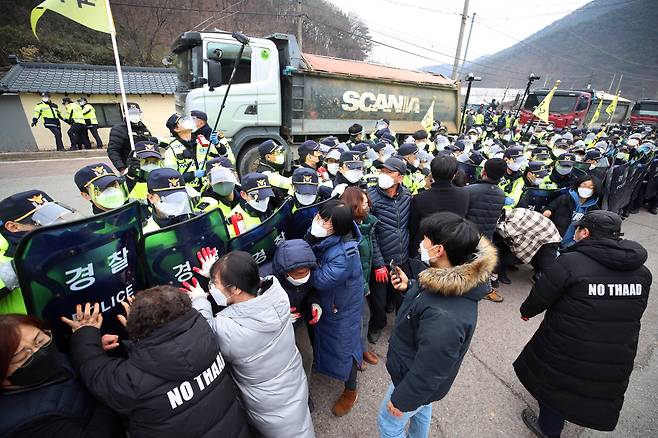 지난달 경북 성주 사드 기지로 공사 장비·자재를 실은 차들이 들어가려 하자 주민과 사드 반대단체 회원들이 저지하며 경찰과 대치하는 모습. /연합뉴스