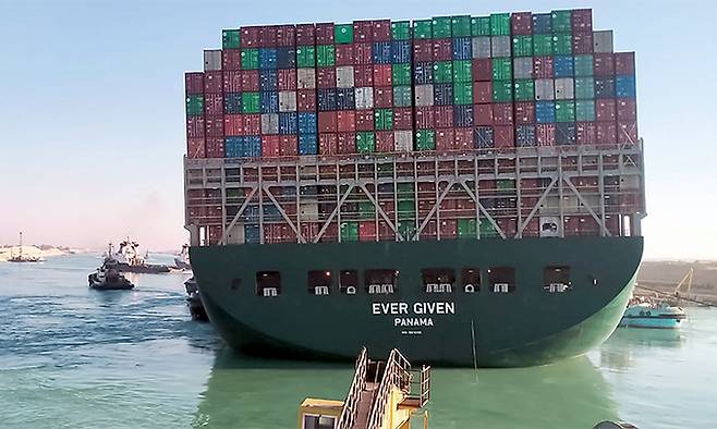 이집트 수에즈 운하를 가로막았던 대형 컨테이너선 에버 기븐호가 29일(현지시간) 움직일 준비를 하고 있다. 배는 이날 밀물 때를 맞춰 정상 항로를 완전히 회복했다. 작은 사진은 선박 추적 서비스인 베슬파인더에 나타난 에버 기븐호의 운항 모습. 베슬파인더 캡처, 수에즈=AFP연합뉴스