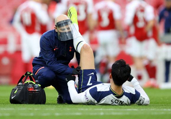 토트넘의 손흥민이 15일(한국시간) 런던 에미레이츠 경기장에서 열린 아스널과의 잉글랜드 프리미어리그 28라운드 원정경기 전반 17분 왼쪽 허벅지 뒷부분인 햄스트링을 붙잡고 쓰러진 뒤 의료진의 응급 처치를 받고 있다. 2분 뒤 다시 통증을 호소한 손흥민은 에릭 라멜라와 교체됐다.런던 로이터 연합뉴스