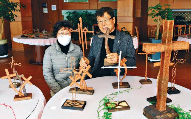 이인영 집사가 지난달 21일 인천 계산교회 6층 로비에 마련된 십자가 전시실에서 구리선 십자가를 들고 부인 나애숙 집사와 포즈를 취하고 있다. 인천=강민석 선임기자