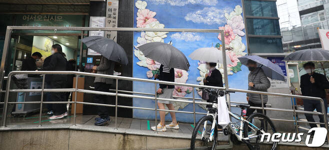 4·7 재·보궐선거 사전투표 둘째날인 3일 오후 서울 마포구 아현동 주민센터에 마련된 사전투표소에서 우산을 쓴 시민들이 투표를 하기 위해 기다리고 있다. 2021.4.3/뉴스1 © News1 임세영 기자