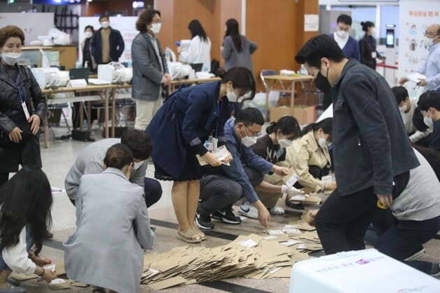 4·7 재·보궐선거 사전투표가 끝난 3일 오후 서울역 설치된 남영동 사전투표소에서 관계자들이 투표함을 열어 관외 투표용지 봉투를 확인하고 있다. 2021.4.3/뉴스1