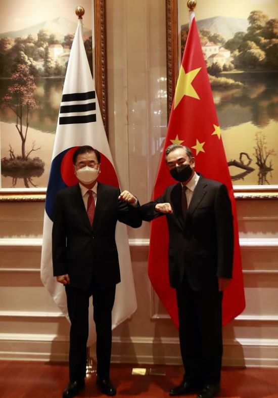 정의용 외교부 장관(왼쪽)과 왕이 중국 외교부장이 3일 중국 푸젠성 샤먼의 하이웨호텔 회담장에서 만나 팔꿈치를 마주 치며 인사를 나누고 있다.  샤먼(중국)= 연합뉴스