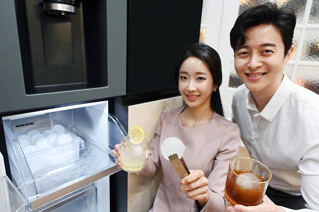 모델이 칵테일, 위스키, 레모네이드, 아이스커피 등 시원한 음료를 집에서도 제대로 즐길 수 있게 해주며 음료의 풍미를 더해주는 지름 약 50밀리미터(mm)의 구형 얼음인 크래프트 아이스(Craft Ice)를 소개하고 있다.(사진: LG전자 제공)