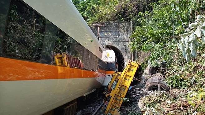 사고 현장 모습. 멈춰 선 열차 옆에 충돌한 공사 차량의 잔해가 있다.