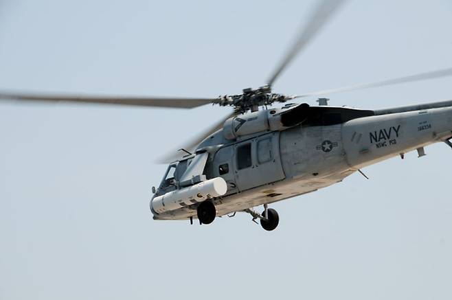 미 해군 MH-60S 헬기가 기뢰 제거장비를 장착한 채 비행하고 있다. 미 해군 제공