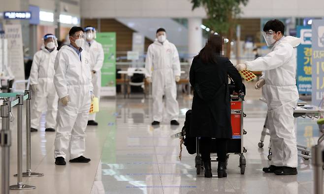 인천국제공항 제2터미널에서 해외 입국자들이 검역지원단의 안내를 받고 있다. 연합뉴스