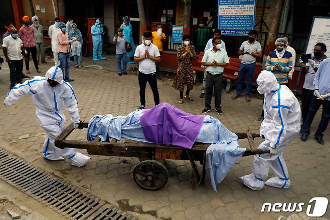 인도 뉴델리에서 코로나19로 인한 사망자를 옮기고 있다.© AFP=뉴스1