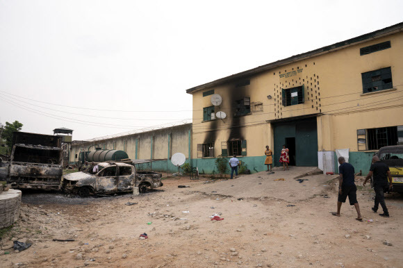 집단 탈옥 사태가 발생한 나이지리아 남동부 오웨리의 한 교정시설 앞에 불에 탄 차량이 놓여 있다. AP=연합뉴스