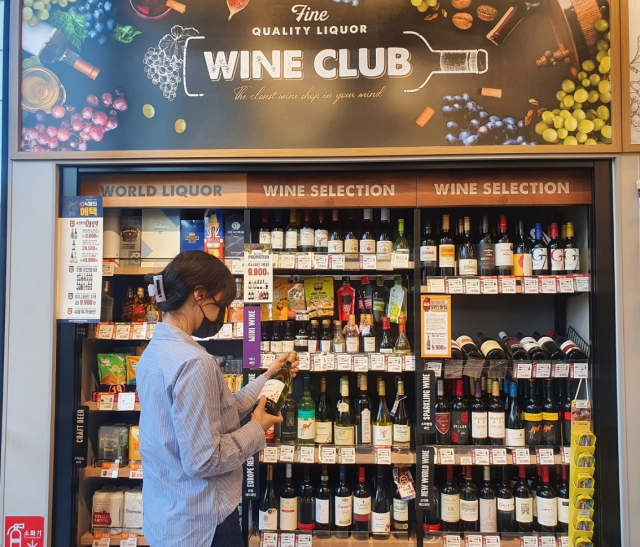 이마트24 매장에서 고객이 와인을 고르고 있다./사진 제공=이마트24