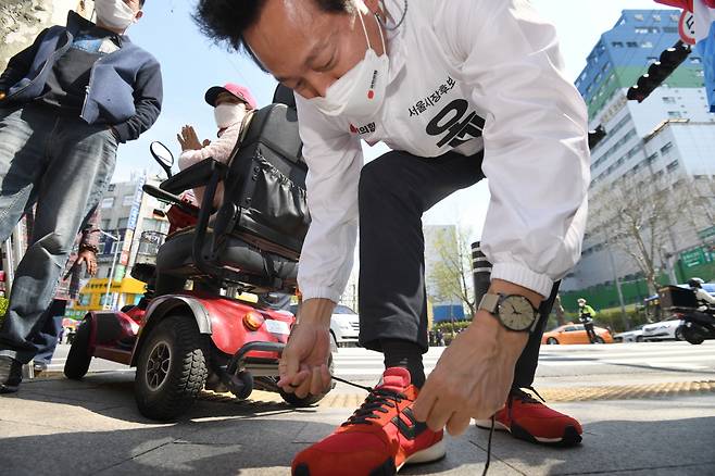 오세훈 후보가 지난 6일 서울 노원구 상계백병원 인근에서 열린 유세에서 참석, 유세차량에 오르기전 운동화끈을 매고 있다. [연합]