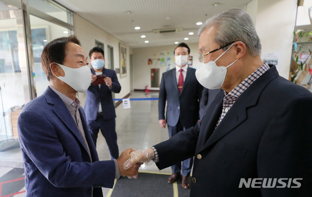 [서울=뉴시스]국회사진기자단 = 4·7 재보궐 선거일인 7일 서울 종로구 하비에르국제학교에 마련된 평창3투표소에서 김종인 국민의힘 비대위원장과 김영삼 전 대통령 차남인 김현철 김영삼민주센터 상임이사가 만나 인사를 나누고 있다. 2021.04.07. photo@newsis.com