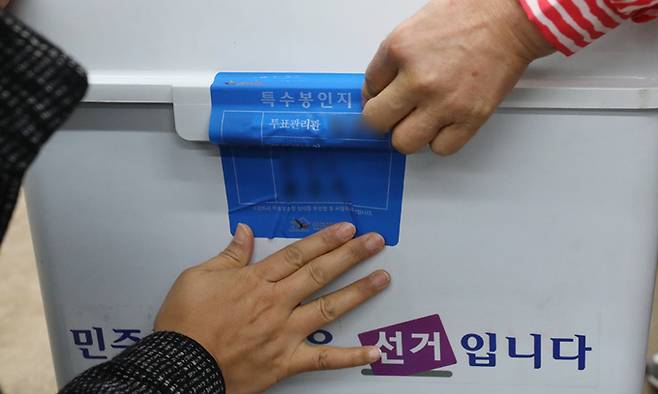 4·7 재보궐 선거일인 7일 서울 노원구 중계동 불암도서관에 마련된 중계본동 제3투표소에서 관계자들이 투표함에 특수봉인지를 붙이고 있다. 뉴스1