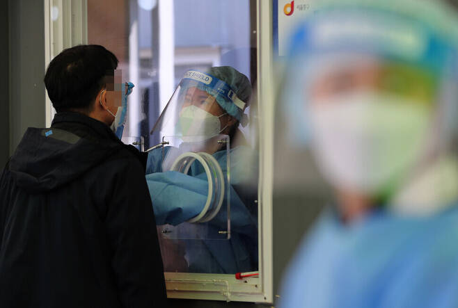 A man gets tested for COVID-19 Wednesday at a temporary screening center at Seoul Station. (Lee Jong-keun/The Hankyoreh)