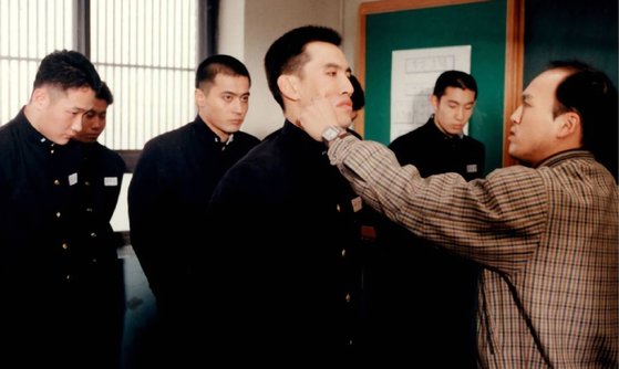 2001년 개봉한 영화 〈친구〉의 한 장면. “느그 아부지 머하시노?”가 구타로 이어지던 교실.