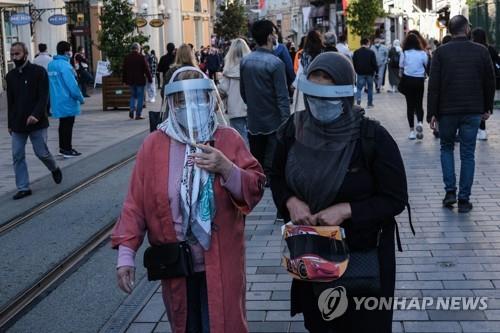 (epa=연합뉴스) 지난 7일(현지시간) 방역 보호 마스크를 쓰고 터키 이스탄불 시내를 산책하는 시민들.