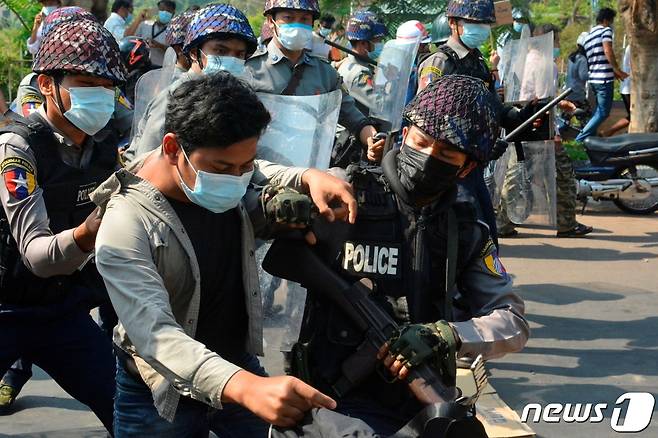 지난 2월12일 미얀마 제3의 도시 모울메인에서 열린 시위에서 경찰들이 시위에 참여한 한 남성을 연행하고 있다. © 로이터=뉴스1 © News1 권영미 기자