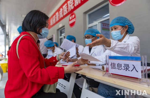 [루이리=신화/뉴시스] 최근 코로나19 환자가 크게 늘어나는 중국 윈난성 루이리에서 주민들이 1일 징청병원에 설치된 코로나19 백신 접종센터에 찾아가 등록을 하고 있다. 2021.04.05
