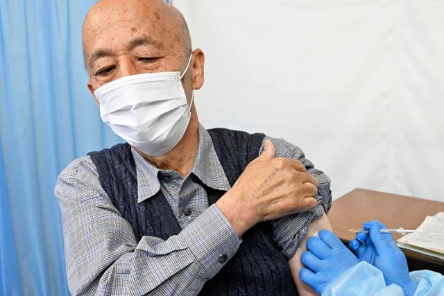 12일 도쿄 하치오지구 구청에서 한 남성이 신종 코로나바이러스 감염증(코로나19) 백신을 접종하고 있다. 이날 일본에서는 고령자 접종이 처음으로 실시됐다. 도쿄=AP 교도 연합뉴스