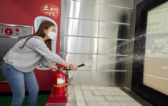 소화기 사용법을 배운 윤시현 학생기자가 불이 난 곳을 향해 소화기를 힘차게 뿌리고 있다.