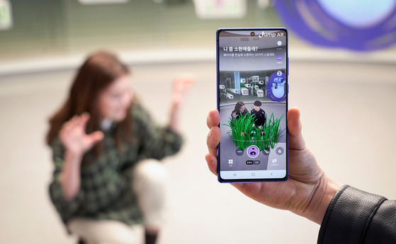 Augmented reality (AR) images appear on a smartphone screen. SK Telecom on Monday announced the ″Jump AR″ app in the U.S., which until now was only available in Korea and Hong Kong on Google's Play store. Users in the U.S. will now be able to experience the AR services, including taking pictures with celebrity avatars. [YONHAP]