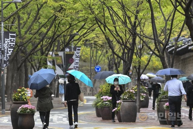 12일 서울 중구 덕수궁 돌담길을 따라 시민들이 우산을 쓴 채 발걸음을 옮기고 있다.