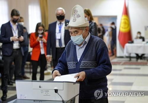 (AP=연합뉴스) 키르기스 전통 모자를 쓴 한 남성이 11일 비슈케크에서 투표하는 모습.