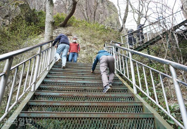 대둔산 케이블카 상부 정류장에서 정상으로 가는 등산로는 처음부터 계단이다. 한 등산객이 손을 짚고 기어오르고 있다.