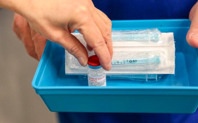 13일(현지시간) 영국 중남부 레딩에 있는 마데스키 경기장에서 의료인이 모더나 백신 접종을 준비하고 있다. 영국은 이날 모더나 백신 접종을 개시했다. 레딩=AP/뉴시스