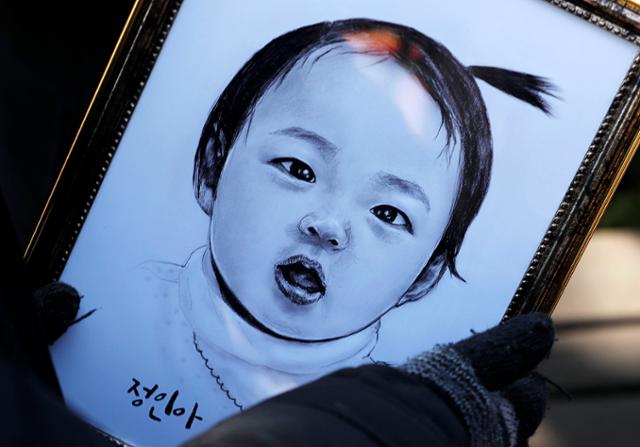 '정인이 사건(생후 16개월 입양아 학대사망 사건)' 공판이 열린 지난달 3일 서울 양천구 서울남부지법 앞에서 한 시민이 정인이 초상화를 바라보고 있다. 뉴시스