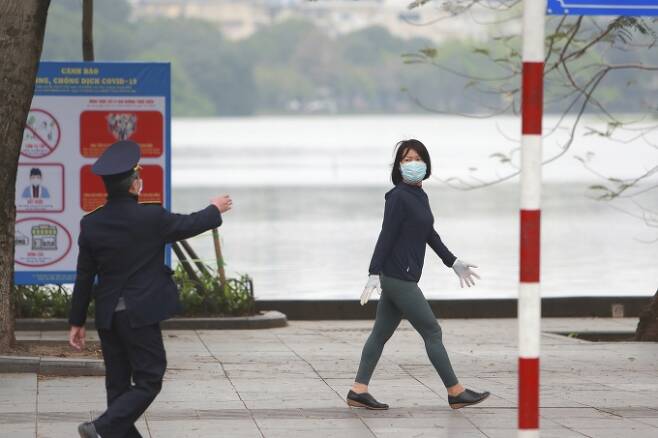 베트남 하노이에서 마스크를 낀 시민들이 걸어가고 있다. [사진=뉴시스]