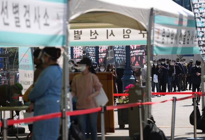 코로나19 확산세가 갈수록 거세지는 가운데 14일 오후 서울역광장에 마련된 임시선별진료소에서 시민들이 검사를 받기 위해 줄을 서고 있다. 연합뉴스