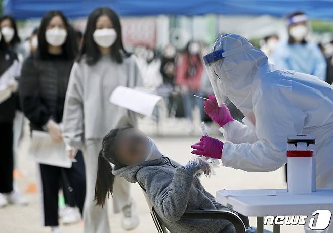 15일 오전 울산 남구 한 중학교 운동장에 마련된 임시 선별진료소에서 2학년 전교생을 대상으로 신종 코로나바이러스 감염증(코로나19) 전수검사가 실시되고 있다. 전날 이 학교 2학년 학생 1명이 코로나19 확진 판정을 받았다. 2021.4.15/뉴스1 © News1 윤일지 기자